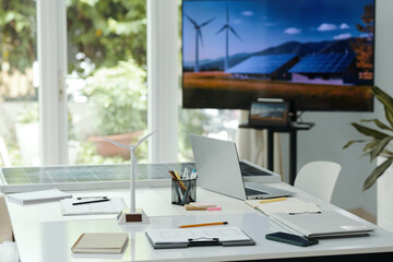 Workplace of engineers with document in board room with big TV for presentation in background