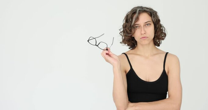 Confident free woman adjusting her glasses on a white background