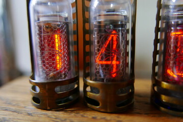 Retro Nixie lamp indicator clock on dark background. The Nixie tube indicator of the numbers of...
