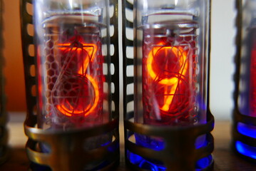 Retro Nixie lamp indicator clock on dark background. The Nixie tube indicator of the numbers of...