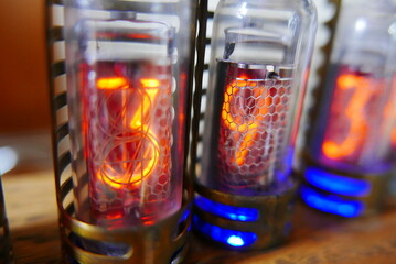 Retro Nixie lamp indicator clock on dark background. The Nixie tube indicator of the numbers of retro style.