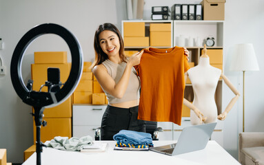 Young business owner woman prepare parcel box and standing check online orders for deliver to...
