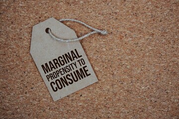 Marginal Propensity To Consume text on price tag top view on cork paper background