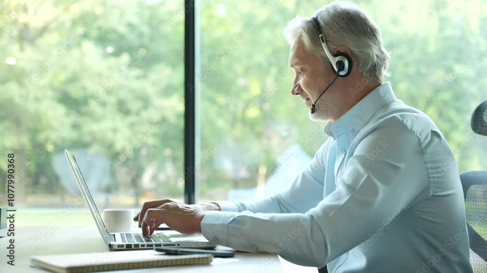 Canvas Prints Smiling businessman using headset when talking to customer. Tech support manager in headset consulting a client. Happy mature male customer support executive working in office.