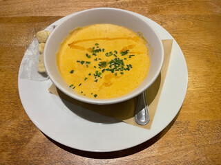 A bowl of lobster bisque soup garnished with chopped chives.