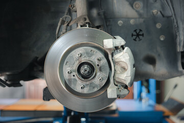 Auto brake caliper on disc brakes of a car. Vehicle repair service. Mechanical technology detail in automotive systems.
