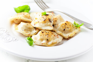Dumplings with potato and cottage cheese stuffing (pierogi). Traditional Polish Christmas Dinner. Bright background.