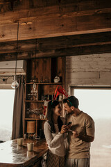 Happy couple using credit card and phone while buying online for Christmas at home.