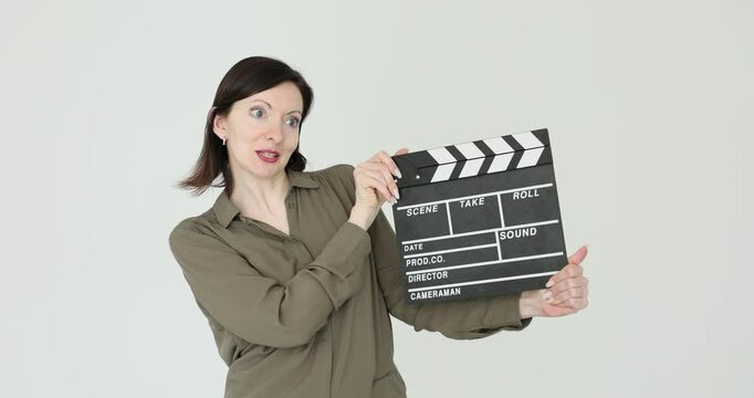 Woman holds clapper board for filming on white background