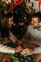 Loving couple preparing Christmas presents in the cozy living room