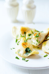 Dumplings with potato and cottage cheese stuffing (pierogi). Traditional Polish Christmas Dinner. Bright background.