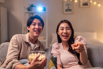 Asian young beautiful woman watching romantic movie on television at home. 