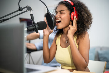 African American DJ woman sing a song on microphone to broadcasting. 