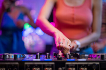 Close up of woman artist DJ mixing and scratching music mixer controller.