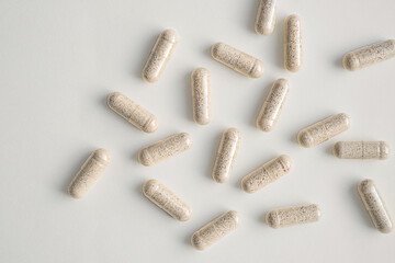 Vitamin capsules scattered on light surface. Health and wellness concepts.