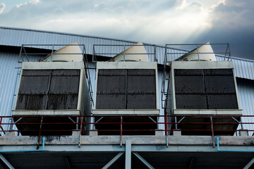 Fototapeta premium Cooling towers in data center building. Air conditioning cooling towers in front of building with fins to the front. Industrial cooling towers or air cooled water chillers with piping system.