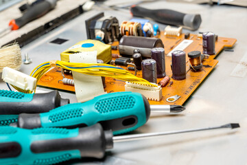 Closeup view of screwdrivers and electronic circuit board with components of microchip, integrated...