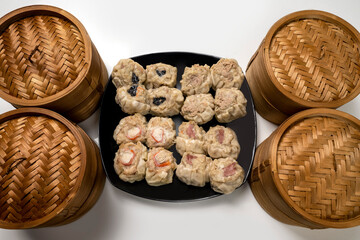 Assorted chinese dim sum dumpling on the plate with bamboo wooden basket bowl isolated over white background