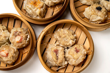Assorted chinese dim sum dumpling on bamboo wooden basket bowl isolated over white background