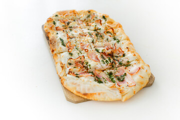 Pizza with bacon in Roman style served with fresh tomatoes on white table at cozy home
