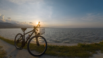 Obraz premium Bicycle on the shore of the lake at sunset, Indonesia