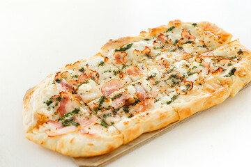 Pizza with bacon in Roman style served with fresh tomatoes on white table at cozy home