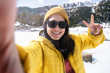 Young Latin woman taking a selfie hiking mountain forest in winter 