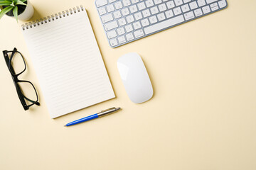 Office desk with computer keyboard, mouse, glasses, notebook and pen. Top view with copy space. Flat lay