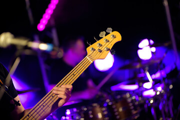 Fototapeta premium Bassiste jouant de la basse sur scène en live, gros plan et arrière plan flou