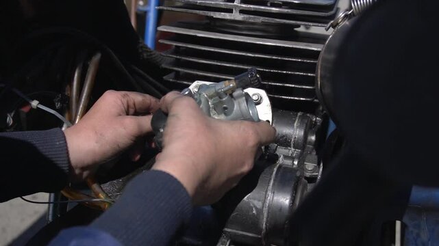 diagnostics and repair of a carburetor, a teen auto mechanic holds a fuel system spare part in his hands.