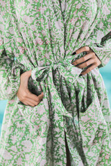 closeup of female green kimono with flowers pattern  asian model daytime by a swimming pool hands on hips