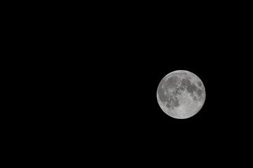 Full moon with visible craters on black sky