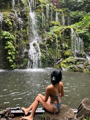 Fototapeta premium Young woman by the waterfall