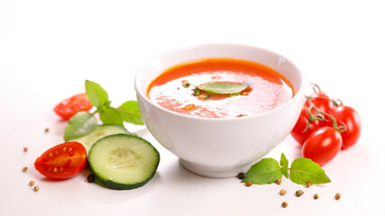 bowl of tomato soup with herb on white background