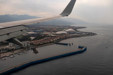 Stunning view of the Ground from under the wing of the aircraft. An amazing landscape opens from the window of the plane. The city of Sochi. Krasnodarskiy kray. Traveling by plane. Flying in the sky