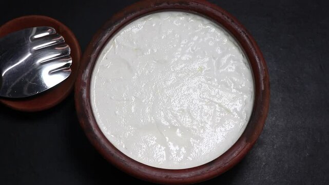 Curd from milk preparation in earthen pot.