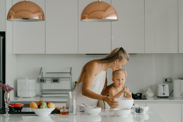 Mother and daughter preparing food in kitchen