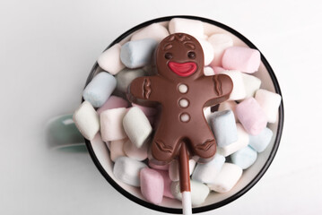 Chocolate man on marshmallow cup, sweet Christmas cookies, close-up, top view