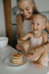 Mother and daughter preparing food in kitchen