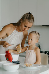 Mother and daughter preparing food in kitchen