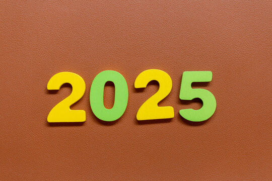 Colorful numbers 2025  on a brown textured background. Perfect for projects celebrating the upcoming year, New Year’s themes