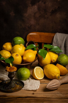 Table with lemons, limes, candle and chair