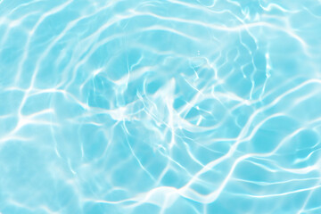 Blue water with ripples on the surface. Defocus blurred transparent blue colored clear calm water surface texture with splashes and bubbles. Water waves with shining pattern texture background.