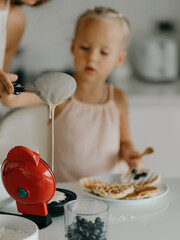 Mother and daughter preparing food in kitchen