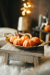 Handmade soy candle in the shape of a tangerine on a light background
