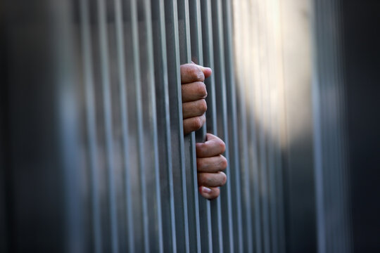 Hands Gripping Metal Bars Symbolizing Confinement, Isolation, and The Human Experience Within the Context of Imprisonment and Emotional Struggles