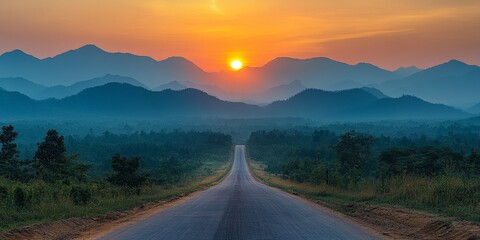 Fototapeta premium Winding road sunset: scenic path leading through hills toward bright horizon