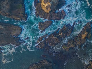 Aerial view of coastal rocks and ocean waves.
