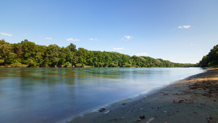 beautiful spring landscape, panoramic view of river and forest from above the hill, bright sunny day turns into sunset and dusk, sunlight reflects from water, river bank and flow of water