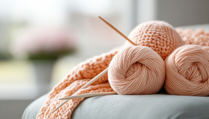 Knitting project in progress with soft peach yarn and wooden needles, creating cozy atmosphere. Perfect for crafting enthusiasts and home decor lovers